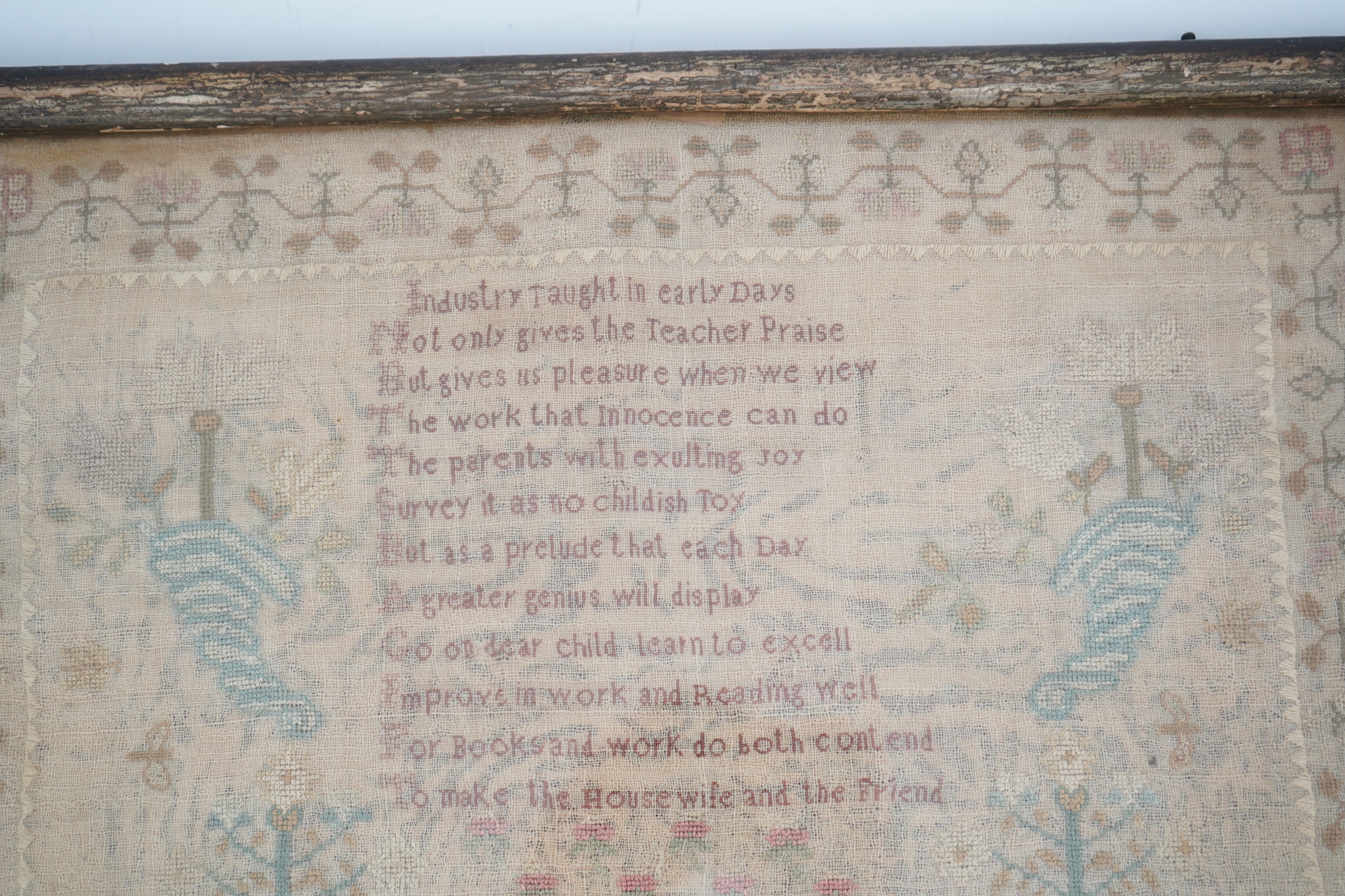 A gilt framed finely worked Regency gauze sampler, by Amelia Artus, aged 8 years, dated 1813, worked on fine gauze with coloured silk threads, with a large central panel having a long verse, two motifs of cornucopia, pot